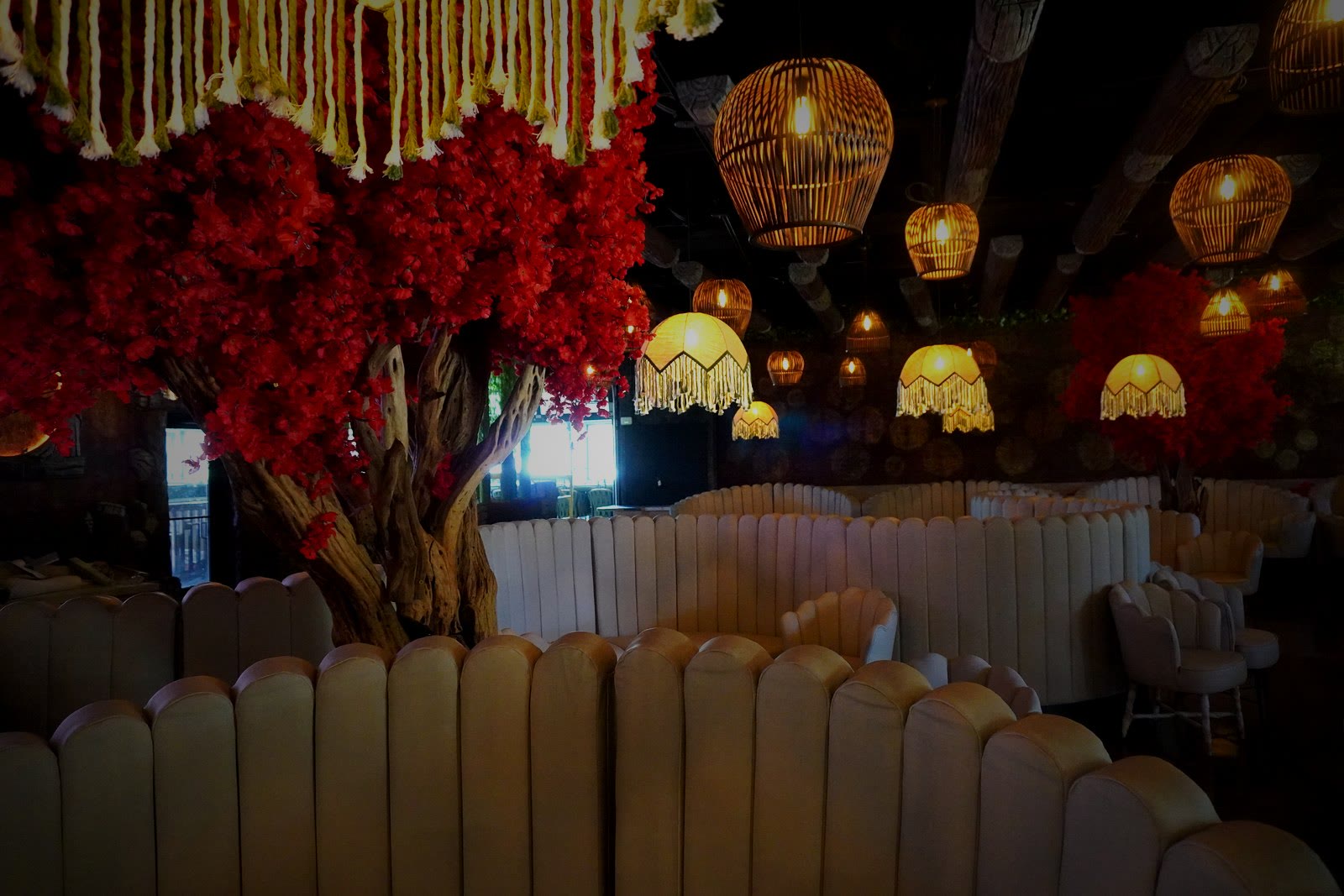 Casa Tequila Prime main dining room — red flowering trees and amber pendant lights